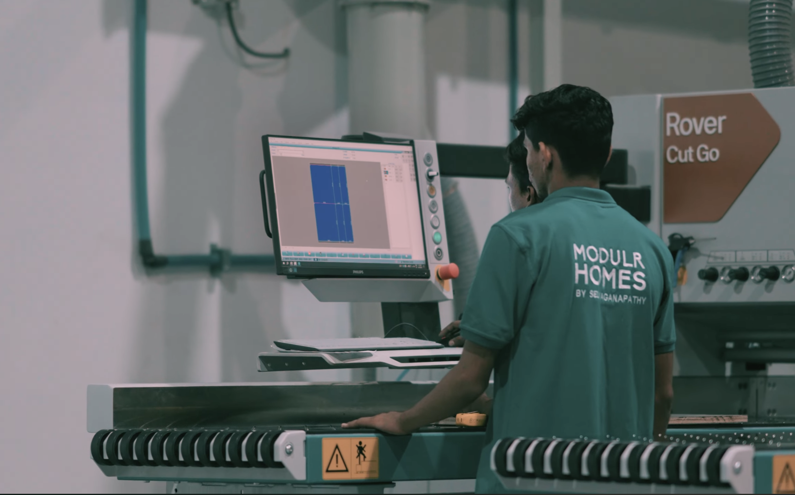 Modulr Homes technicians operating a CNC cutting machine